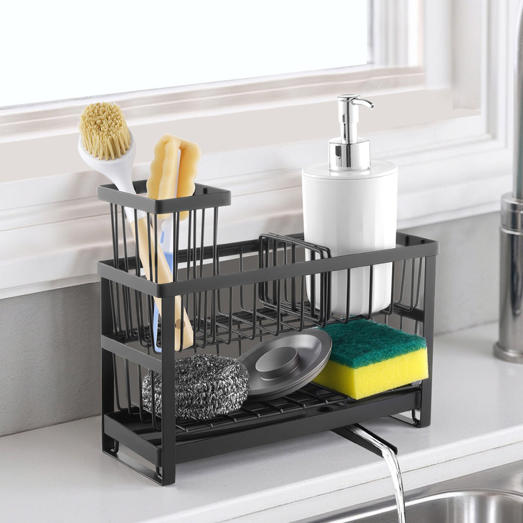 Black sink caddy beside a faucet holding brushes, sponges, scrubbers, and two pump bottles