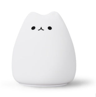 Small white cat-shaped lamp with a simple black face on a white background
