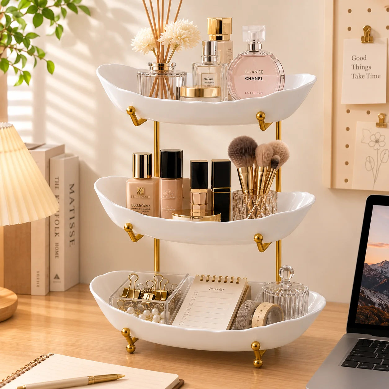 White tiered tray stand holding perfume, cosmetics, brushes, and small accessories