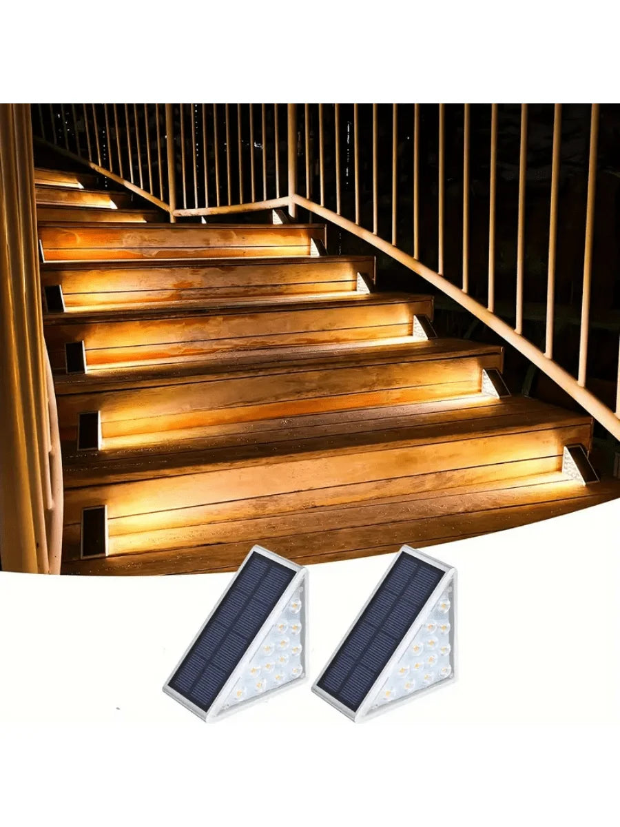 Two white triangular lights shown below illuminated wooden stairs with railings.