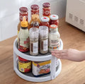 Round white two-tier turntable holding assorted condiment bottles