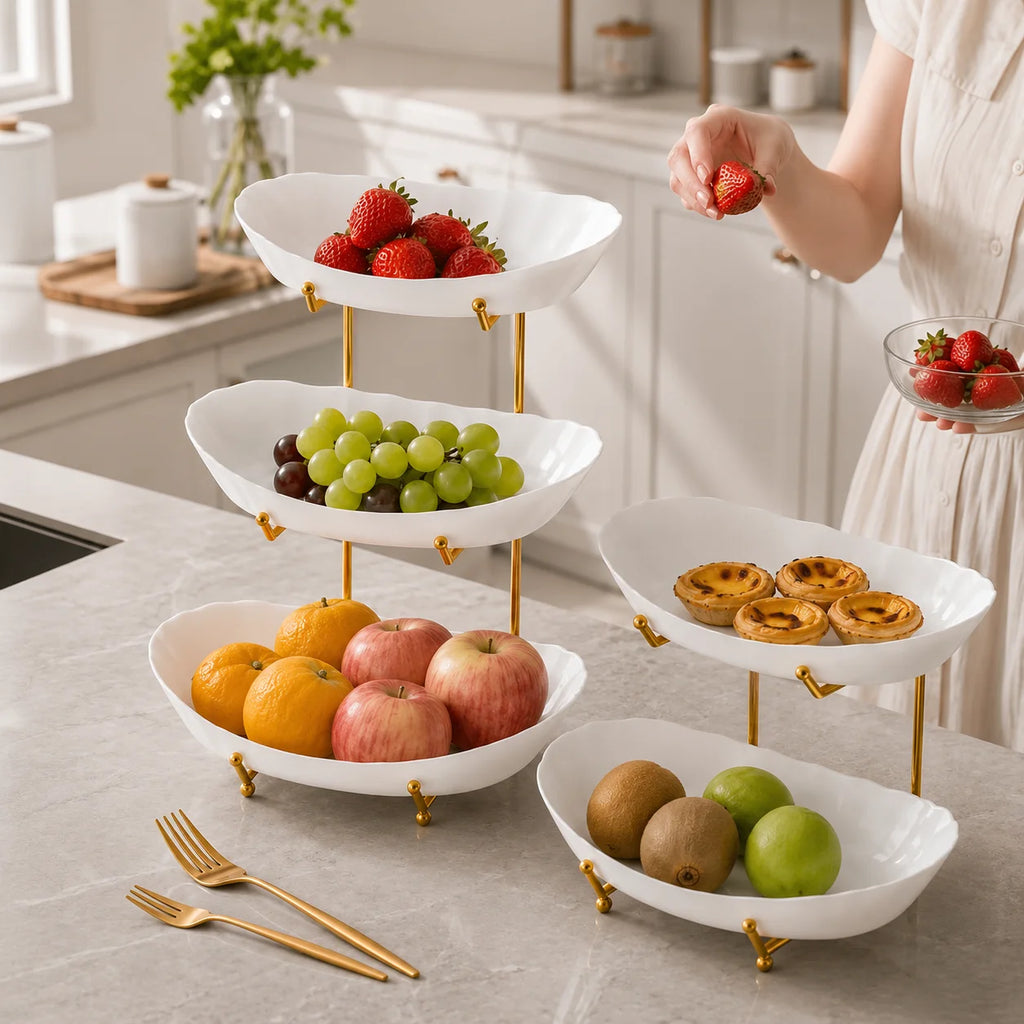 White three-tier serving stand displaying fruit and pastries in a kitchen